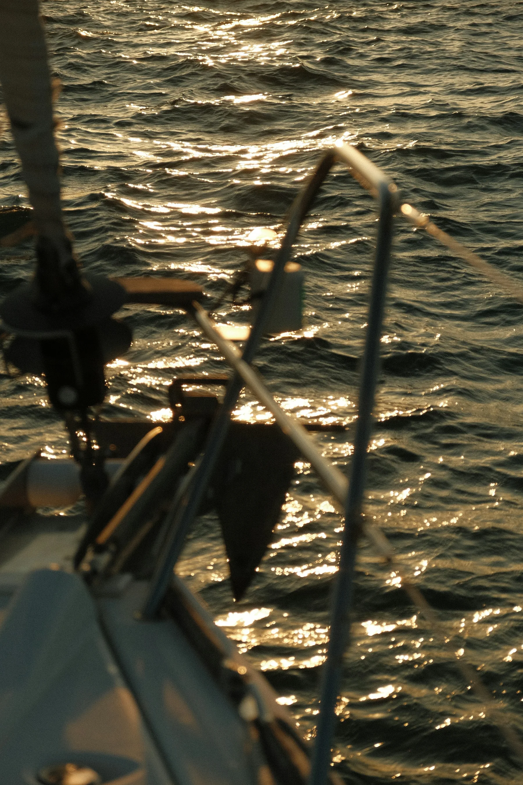 Warm light on the water and the bow rail of a sailing boat on the Tagus.